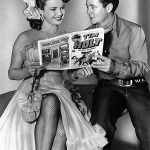 RUSTLERS, Tim Holt, showing Martha Hyer his eponymous comic book, 1949