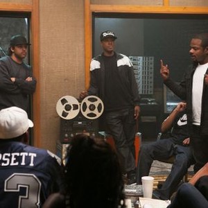 STRAIGHT OUTTA COMPTON, Jason Mitchell, as Eazy-E (sitting, left), O'Shea Jackson Jr., as Ice Cube (arms folded), Corey Hawkins, as Dr. Dre (standing, center), director F. Gary Gray, on set, 2015. ph: Jamie Trueblood/©Universal Pictures