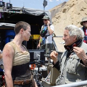 MAD MAX: FURY ROAD, Charlize Theron (left of center), director George Miller (right), on set, 2015. ph: Jasin Boland/©Warner Bros.