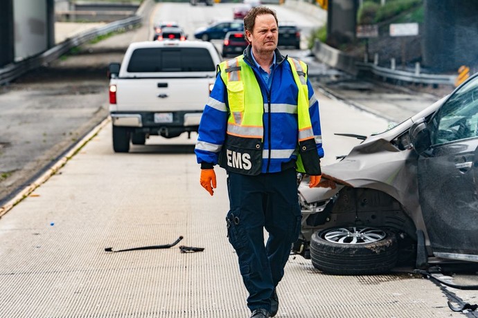 EMT with yellow safety vest at car crash in Code 3