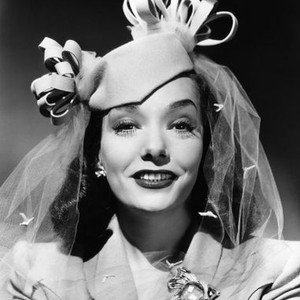 MEXICAN SPITFIRE'S BABY, Lupe Velez, in a beige felt pillbox and a gold brooch set with aquamarine, rubies and diamonds, 1941