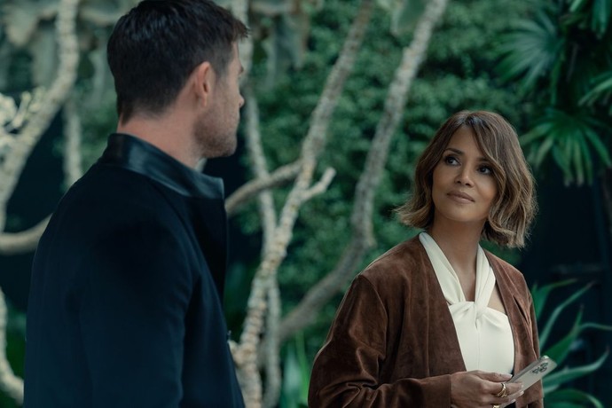 man in black talks to woman in brown jacket in Crime 101