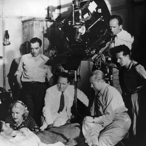 GREEN LIGHT, Errol Flynn, Anita Louise, Walter Abel (standing left), director Frank Borzage (seated in jacket) filming on set, 1937