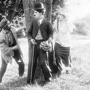 THE TRAMP, (aka CHARLIE ON THE FARM; CHARLIE THE HOBO; CHARLIE THE TRAMP), from left: Leo White, Charles Chaplin, Edna Purviance, 1915