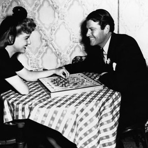 THE MORE THE MERRIER, from left, Ann Savage, Joel McCrea, playing 'Battle Checkers' between takes, 1943