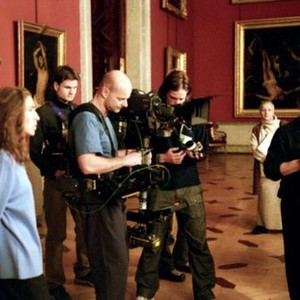 RUSSIAN ARK, cinematographer Tilman Buttner (bald, holding Steadicam), director Aleksandr Sokurov (right, in glasses, looking down), on location in the Hermitage, 2002. ©Wellspring