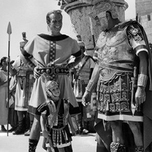 Charlton Heston (left) on the film's set in Rome with his three-year old son Fraser (center). Co-star Jack Hawkins (right) is shown chatting with Heston and his son during a break from filming.