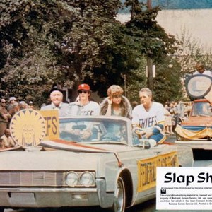 SLAP SHOT, riding in front car from left: Strother Martin, Michael Ontkean, Lindsay Crouse, Paul Newman, 1977