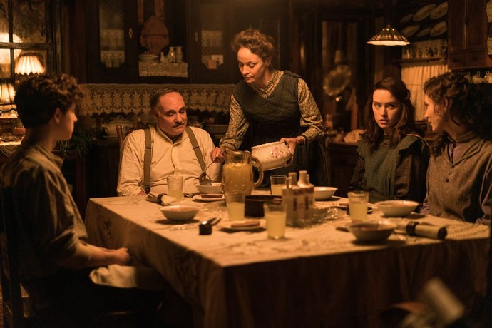 (L–R) Henry Jr. Ederle (Ethan Rouse), Henry Ederle (Kim Bodnia), Gertrude Ederle (Jeanette Hain), Trudy Ederle (Daisy Ridley), and Meg Ederle (Tilda Cobham-Hervey) have dinner, in "Young Woman and the Sea." (Walt Disney Studios)