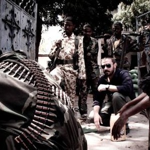 DIRTY WARS, Jeremy Scahill (crouching), 2013.