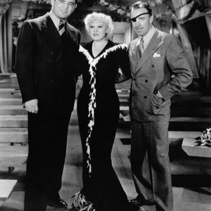 KLONDIKE ANNIE, boxer James Braddock, left, visits Mae West, director Raoul Walsh, on-set, 1936