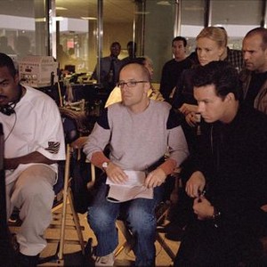 THE ITALIAN JOB, Director F. Gary Gray, producer Donald De Line, Charlize Theron, Mark Wahlberg, Jason Statham watching playback on the set, 2003, (c) Paramount