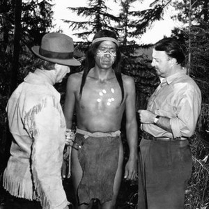 CANYON PASSAGE, technical advisor Nipo Strongheart, (left), director Jacques Tourneur, (right), check makeup on extra, 1946