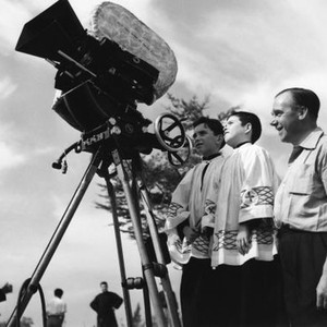 THE MAN WHO NEVER WAS, director Ronald Neame shows the camera to two Spanish choirboys. 1956, TM and Copyright (c) 20th Century-Fox Film Corp. All Rights Reserved