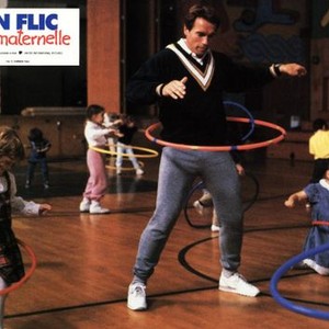 KINDERGARTEN COP, Arnold Schwarzenegger (center), 1990, playing with the hula hoop