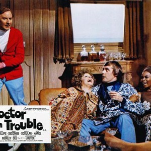 DOCTOR IN TROUBLE, Leslie Phillips (left), Simon Dee (seated center), Sylvana Henriques (seated right), 1970