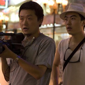 Director Yung Chang (right) and Director of Photography Wang Shi Qing on location in Liberty Square in Chongqing City for UP THE YANGTZE, a film by Yung Chang, a Zeitgeist Films release. photo 5