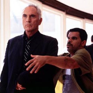 Ed (right, LUIS GUZMAN) urges Wilson (TERENCE STAMP) not to take out his weapon.
