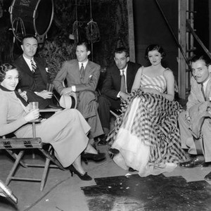 THE THIN MAN, from left: Maureen O'Sullivan, William Powell, director W.S. Van Dyke, Myrna Loy visited by Ronald Colman (right) on set, 1934