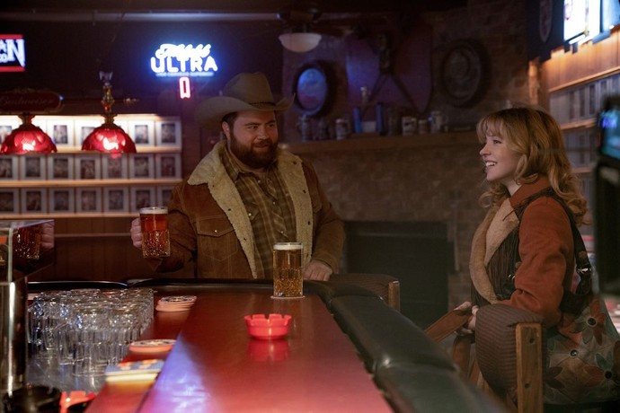 Lefty Ledbetter (Paul Walter Hauser) and Penny Jo Poplin (Sydney Sweeney) get to know each other in a bar in "Americana." (Lionsgate)