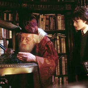 Harry Potter (DANIEL RADCLIFFE, right) watches as Professor Dumbledore (RICHARD HARRIS) feeds Fawkes the Phoenix in Warner Bros. Pictures' "Harry Potter and the Chamber of Secrets."