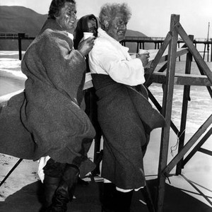 THE SEA HAWK, Errol Flynn, Alan Hale Sr., warm themselves on location, 1940