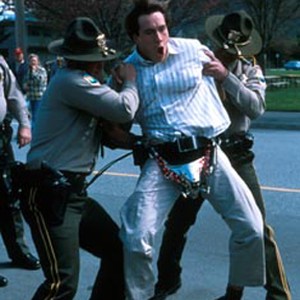 Gilly (CHRIS KLEIN) wears "The Disabler," a male chastity belt complete with a metal cup, leather straps and a padlock, when he is falsely arrested by the police for sexual deviancy. photo 6