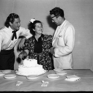 THEY DIED WITH THEIR BOOTS ON, Errol Flynn, (left), director Raoul Walsh, (right), celebrating script girl's birthday on-set, 1941