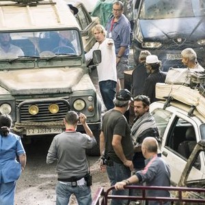 13 HOURS: THE SECRET SOLDIERS OF BENGHAZI, John Krasinski (in vehicle, left), James Badge Dale (in vehicle, right), director Michael Bay (center, white shirt), on set, 2016. ph: Christian Black/©Paramount Pictures