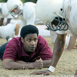 Denzel Washington (center) stars as coach Herman Boone, who in 1971 is selected to coach the T.C. Williams High School team, the Titans.