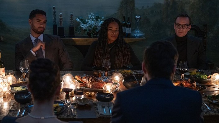 (L–R, background) Col. James Stokes (Regé-Jean Page), Dr. Zoe Vaughan (Naomie Harris), and George Woodhouse (Michael Fassbender) during a spy dinner party, in "Black Bag." (Focus Features)