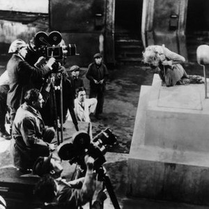 METROPOLIS, director Fritz Lang (kneeling) and crew filming Brigitte Helm (right) on set, 1927