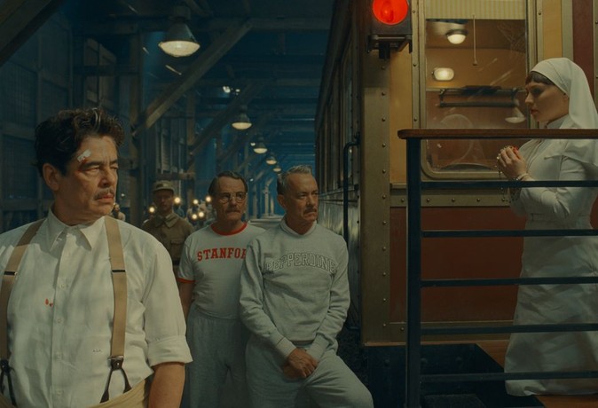 (L–R) Zsa-zsa (Benicio Del Toro), Reagan (Bryan Cranston), Leland (Tom Hanks), and Liesl (Mia Threapleton) get ready to play a basketball game in a train station, in the "The Phoenician Scheme. "(Focus Features/Universal Pictures)
