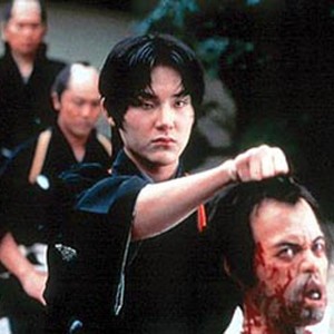 Kano (Ryuhei Matsuda) shows his commander the head of a man he has just decapitated. photo 1