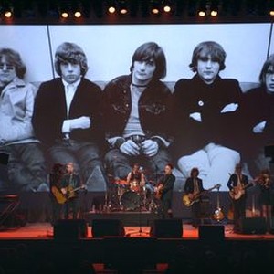 ECHO IN THE CANYON, ON STAGE: JAKOB DYLAN (CENTER); PHOTOGRAPH ON SCREEN: THE BYRDS: ROGER MCGUINN, CHRIS HILLMAN, GENE CLARK, DAVID CROSBY, MICHAEL CLARKE, 2018. © GREENWICH ENTERTAINMENT
