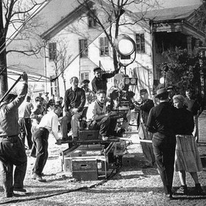BABY DOLL, cinematographer Boris Kaufman (glasses, dark shirt, sitting to the left on the camera dolly), director Elia Kazan (sitting next to the camera), foreground right: Eli Wallach, Carroll Baker, on set, 1956