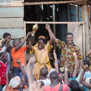 QUEEN OF KATWE, Madina Nalwanga (orange shirt), Lupita Nyong'o (trophy), David Oyelowo (print shirt), 2016, ph: Edward Echwalu/© Walt Disney Pictures