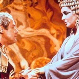 Julius Caesar (REX HARRISON) kneels in front of Cleopatra (ELIZABETH TAYLOR) in CLEOPATRA. photo 1