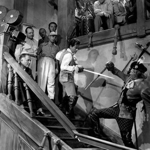 THE SWORDSMAN, director Joseph H. Lewis (checked shirt, top of stairs), Larry Parks (swordsman, center), George Macready (swordsman, lower right), on set, 1948