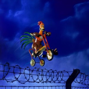 CHICKEN RUN, 2000, Rocky (Mel Gibson) flying over the fence on a tricycle.