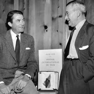 Producer-director William Wyler (right), receiving congratulations from Gregory Peck after Wyler's film, FRIENDLY PERSUASION, won the Cannes Film Festival's Golden Palm Award for best picture of the year, 1956