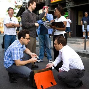 CLOVERFIELD, producer J.J. Abrams (kneeling, left), director Matt Reeves (standing, center), producer Bryan Burk (kneeling, right), on set, 2008. ©Paramount
