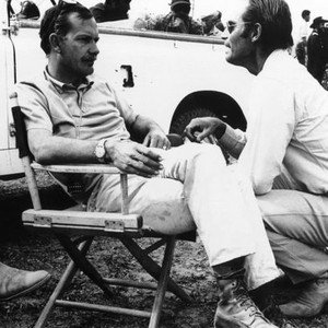 MAJOR DUNDEE, from left: director Sam Peckinpah, Charlton Heston on set, 1965