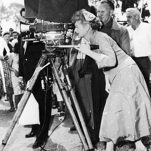 THE LONG, LONG TRAILER, Lucille Ball looks through the camera as cinematographer Robert Surtees stands behind her, 1954