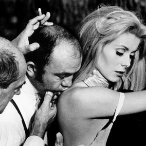 BELLE DE JOUR, Director Luis Bunuel (far left), Catherine Deneuve, on set. 1967