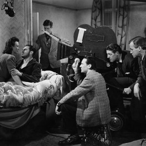 IT ALWAYS RAINS ON SUNDAY, from left on bed: Googie Withers, John McCallum; foreground far right, hand on knee: director Robert Hamer, on set, 1947 iaros1947-fsct18(iaros1947-fsct18)